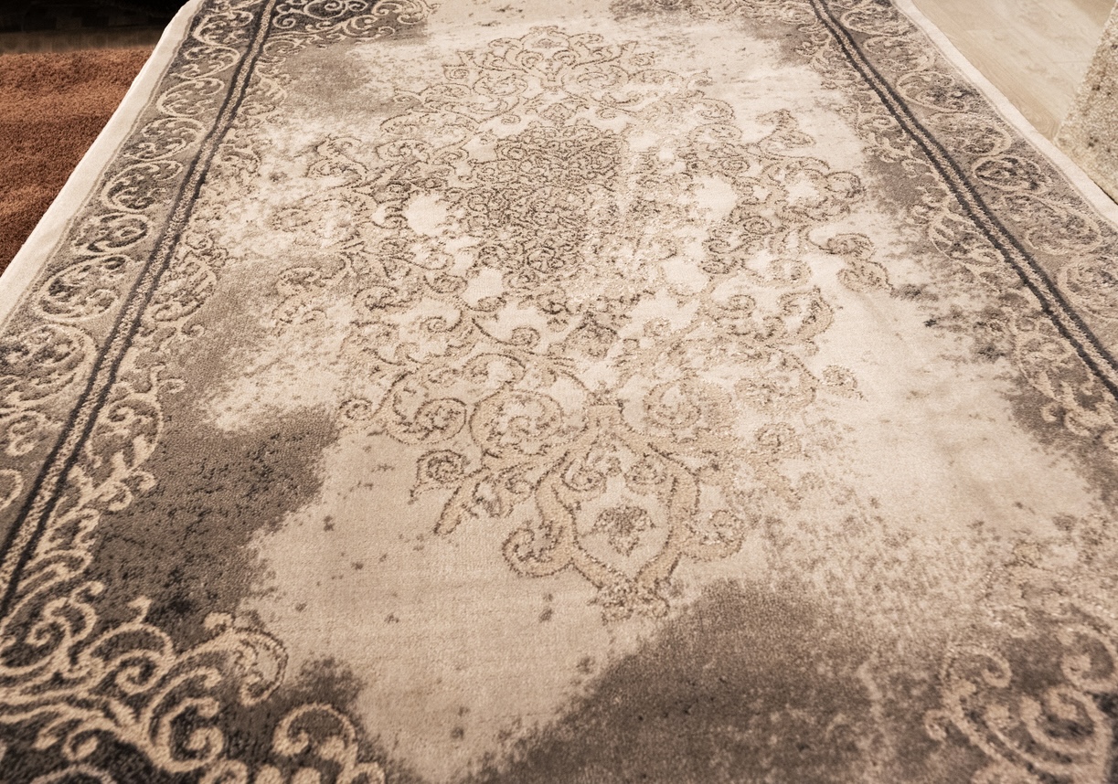 Rug with visible fire damage being inspected for remediation